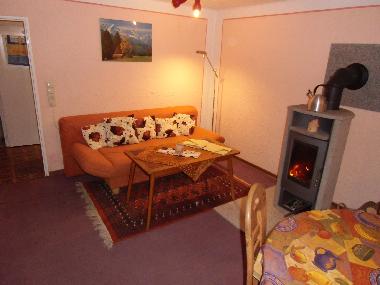 Wohn-/Ezimmer mit Sofa, Kaminofen und Etisch