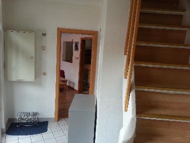 Hausflur mit Blick ins Wohnzimmer und auf die steile Treppe ins OG
