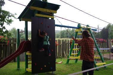 Spielturm, Kletterwand, Rutsche, Reckstange, 2 Schaukeln, Kletternetz, -leiter und -seil. 25-m-Slakl