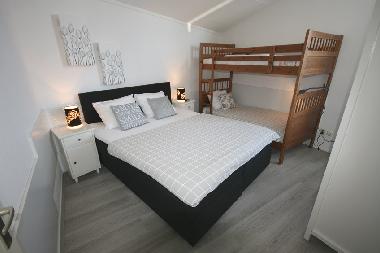 Schlafzimmer mit Doppelbett und Etagenbett