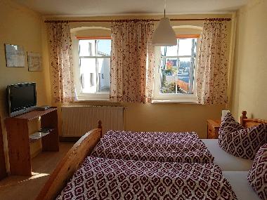 Schlafzimmer mit Doppelbett und TV
