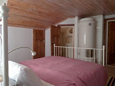 Schlafraum mit Doppelbett und abgetrenntem WC / Waschplatz